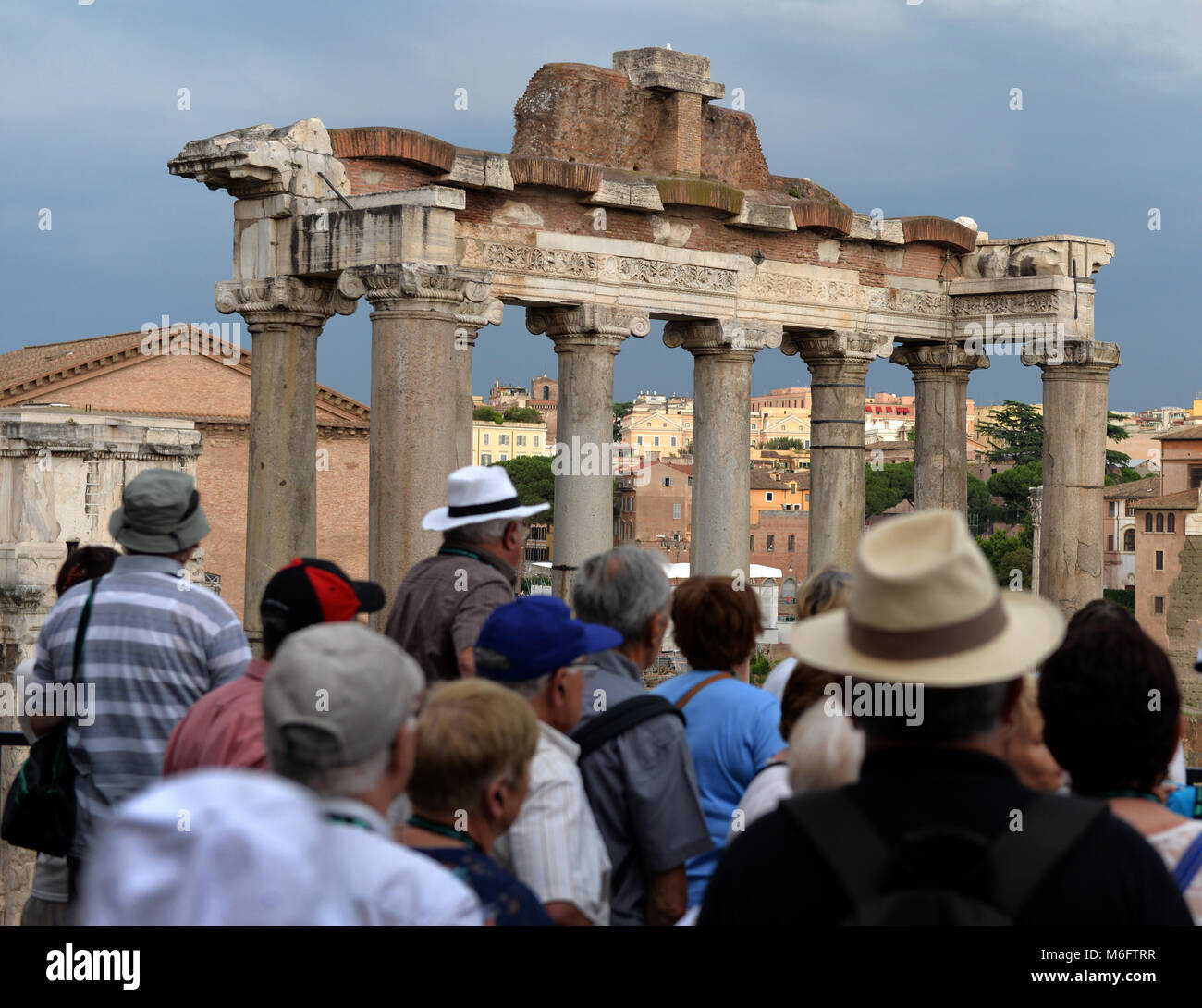 Touristen genießen die Ruinen eines römischen Tempels und entfernte Gebäude der Kirche in Rom, Italien Stockfoto