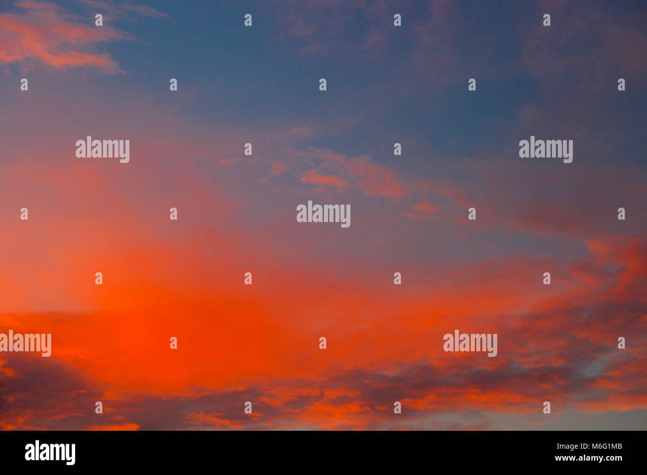 Dramatischer Sonnenuntergang Himmel mit Wolken in kräftigen Rot- und Orangetönen gestrichen Stockfoto