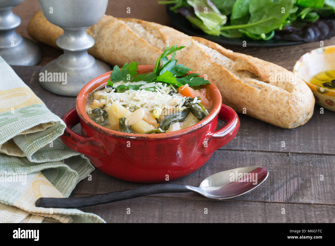 Herzhaftes aus weißen Bohnen und Gemüse Suppe Eintopf serviert in einem  roten Topf mit einem Laib Weizen französischem Brot. Essen Szene,  hausgemachte Güte Stockfotografie - Alamy