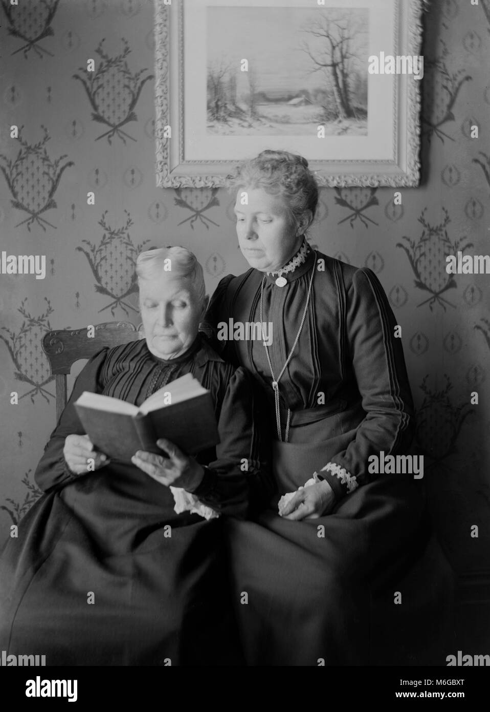 Senior viktorianische Frauen lesen zusammen ein Buch, Ca. 1900. Stockfoto