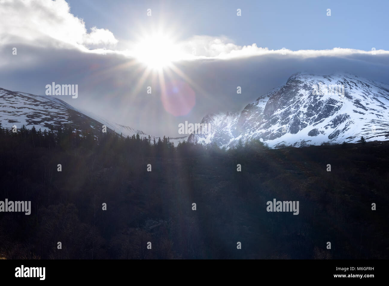 Die Sonne bricht durch die Wolke über die Nordwand des Ben Nevis an einem Wintertag in den Highlands von Schottland, Großbritannien. Stockfoto