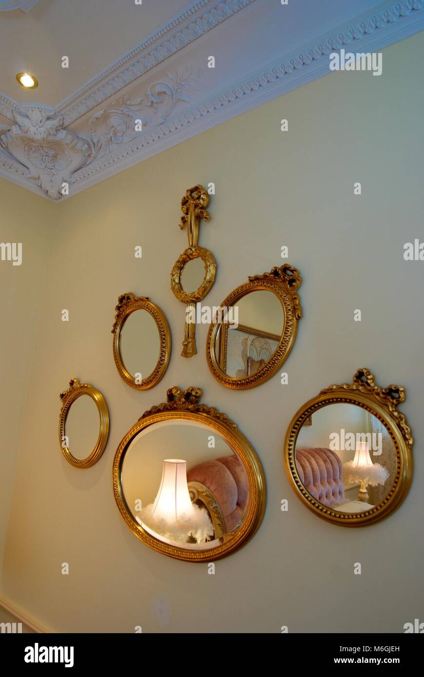 Die Zusammensetzung ovaler Spiegel in einem goldenen Rahmen. Klassischer Innenraum Stockfoto