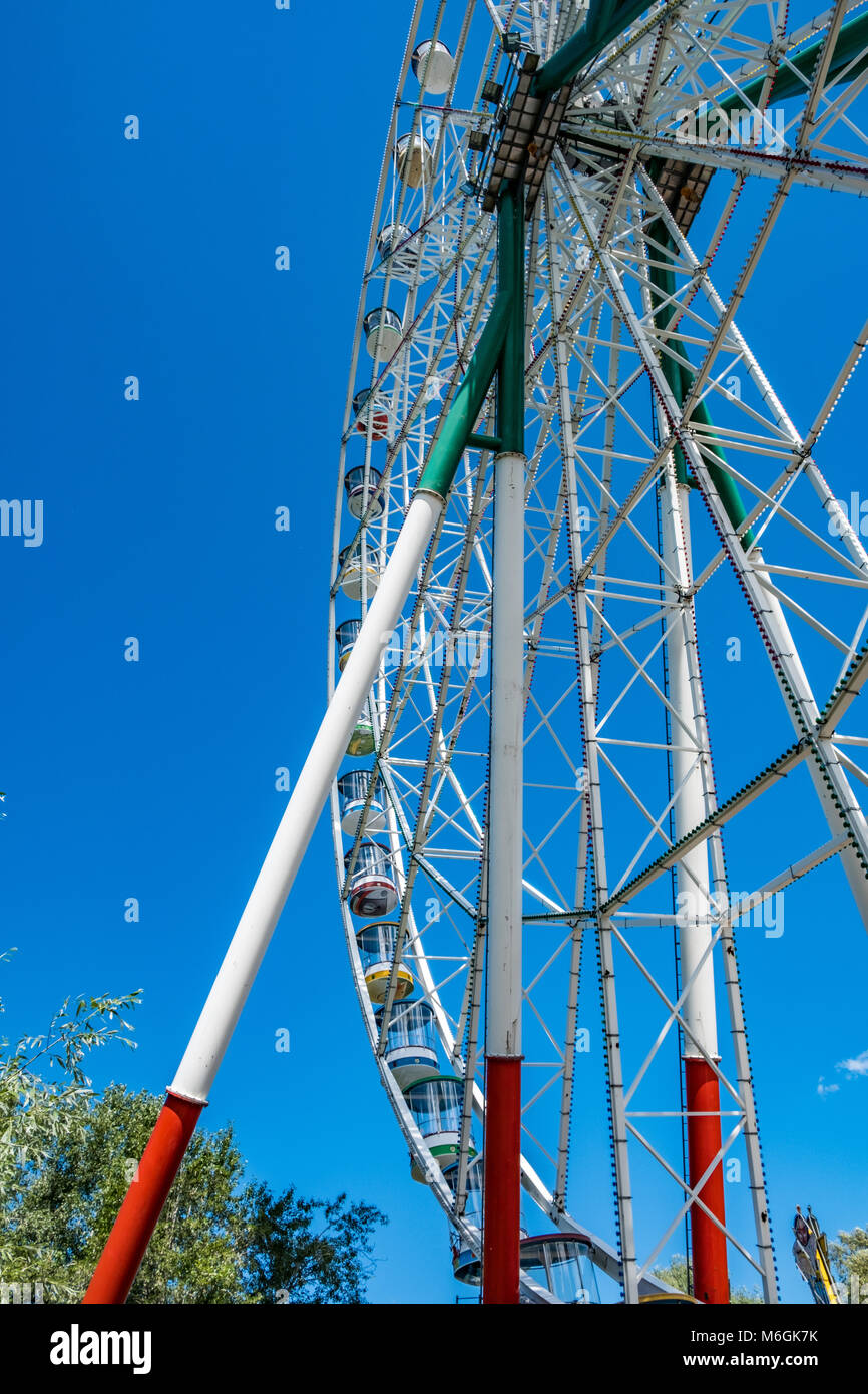 Riesiges Riesenrad gegen den blauen Himmel im Unterhaltungspark mit Blick auf den niedrigen Winkel Stockfoto