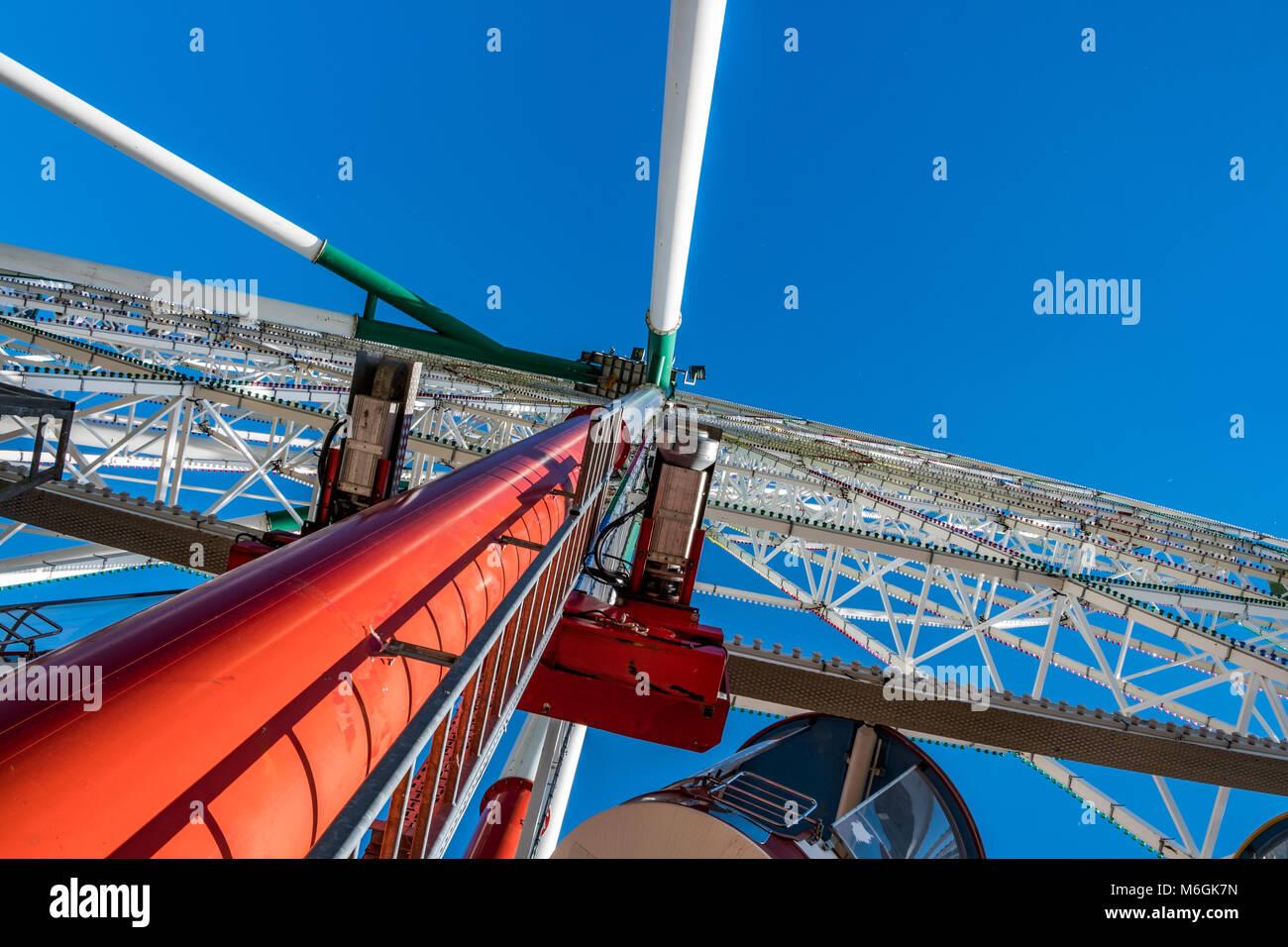 Riesiges Riesenrad gegen den blauen Himmel im Unterhaltungspark mit Blick auf den niedrigen Winkel Stockfoto