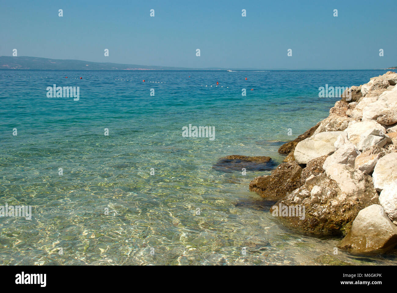 Kristallklares Wasser am felsigen Strand an einem sonnigen Tag Stockfoto