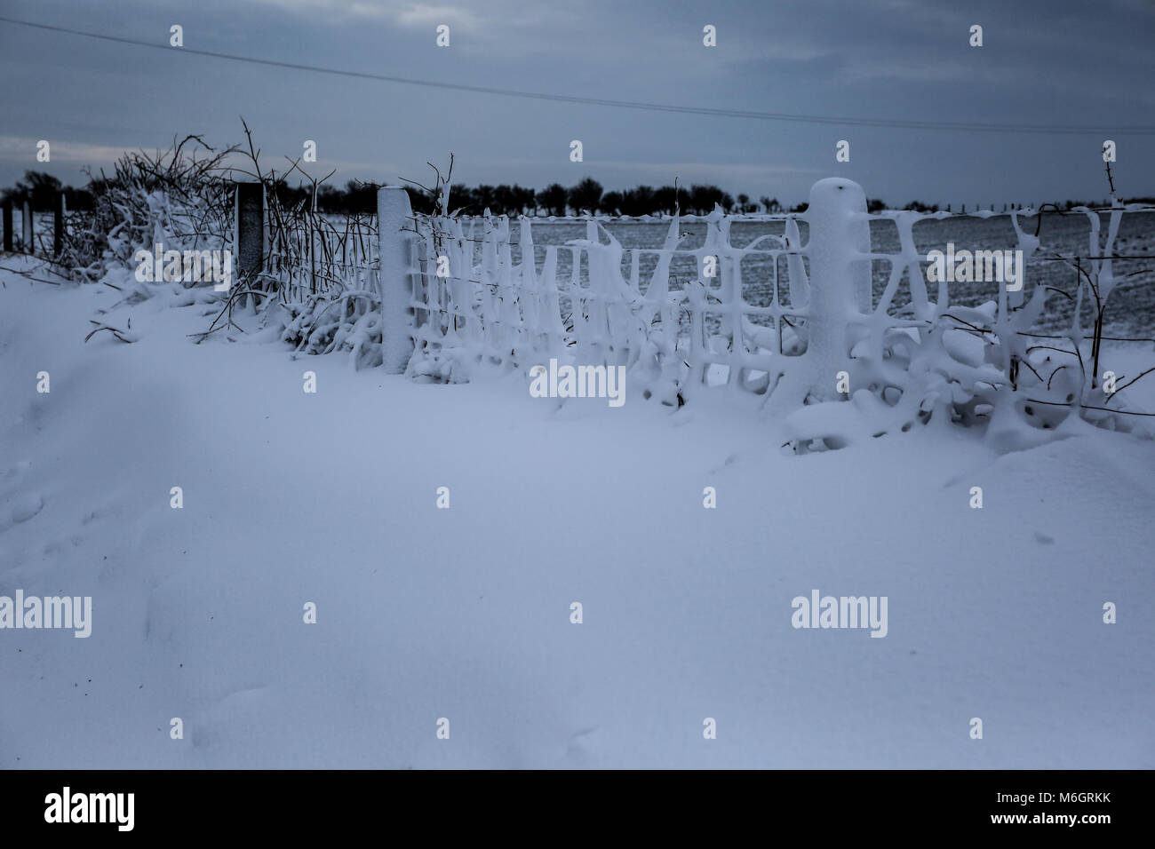 Die Nachwirkungen von Sturm Emma befindet sich im Küstenort Abersoch gesehen, mit einer starken Schneeverwehungen, Wind, Schnee am Strand und eine gefrorene Hafen. Stockfoto