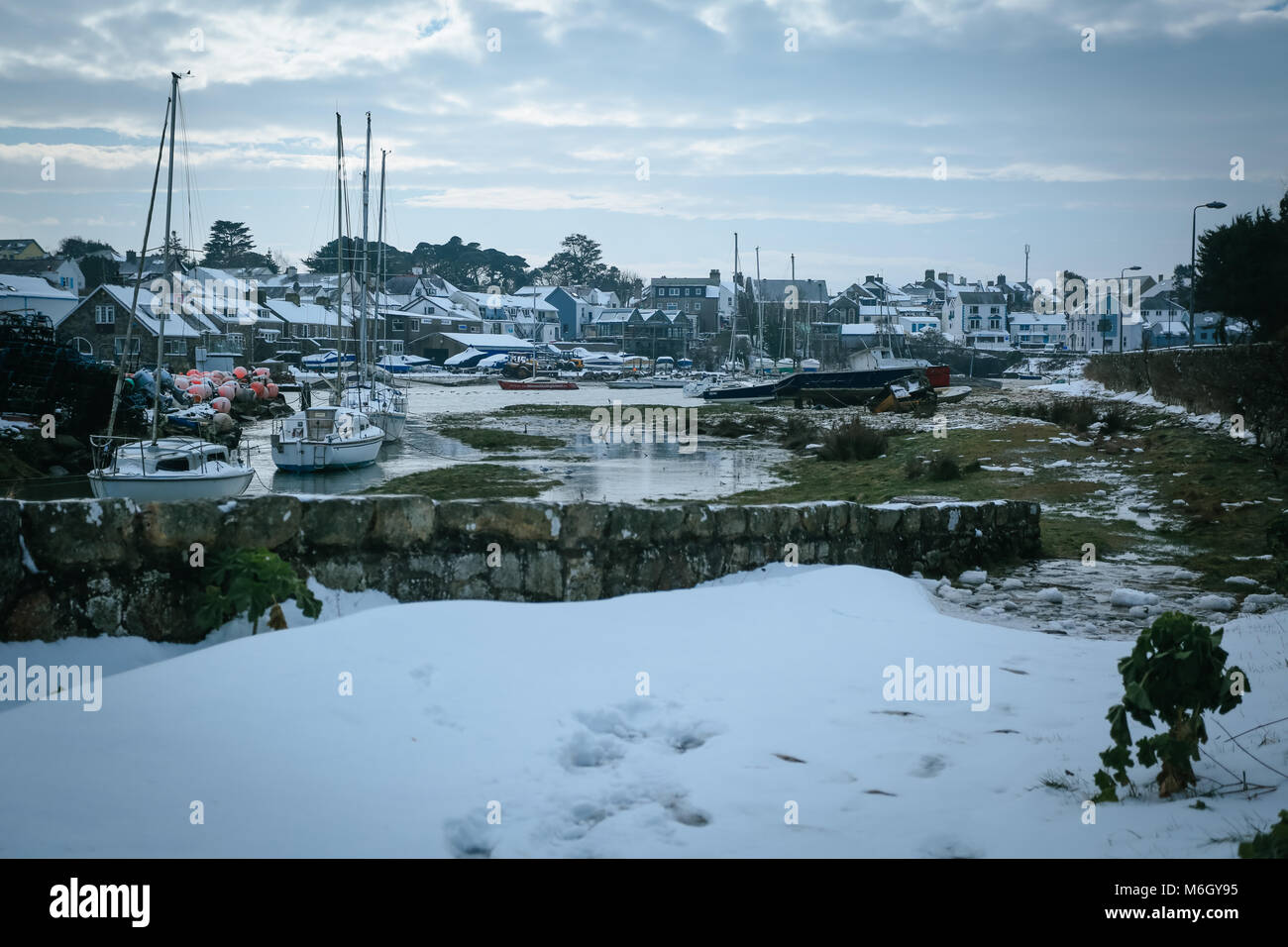 Die Nachwirkungen von Sturm Emma befindet sich im Küstenort Abersoch gesehen, mit einer starken Schneeverwehungen, Wind, Schnee am Strand und eine gefrorene Hafen. Stockfoto