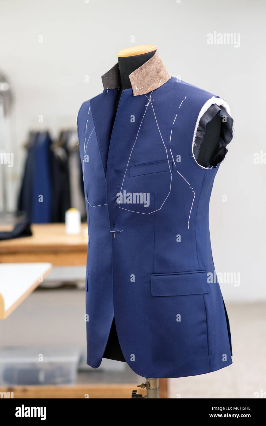 Teilweise neuen blauen Anzug Jacke auf ein Mannequin in der Werkstatt eines Fertigung individuell maßgeschneiderte Kleidung abgeschlossen Stockfoto