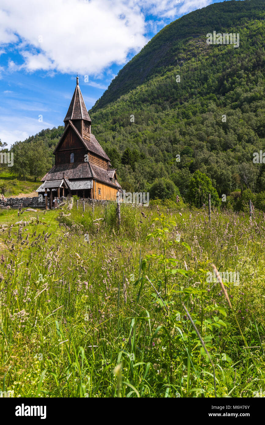 Urnes Stabkirche in der grünen Berglandschaft, Ornes, Norwegen, Weltkulturerbe an der Lustrafjorden, Sognefjorden Stockfoto