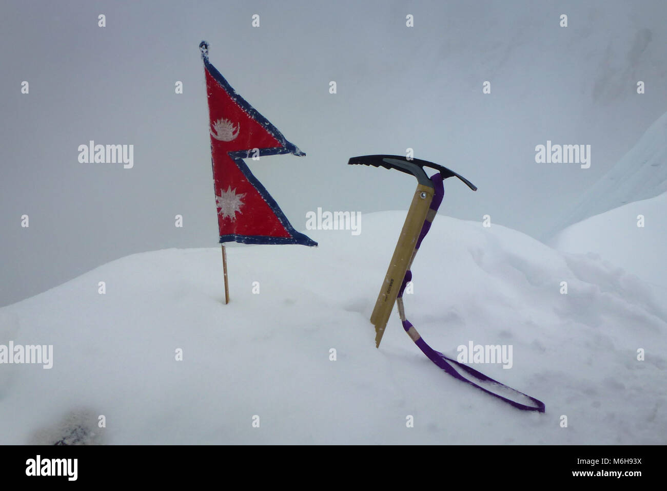 Eispickel und nepalesische Flagge im Schnee auf dem Gipfel des Imja Tse, Island Peak, Everest Base Camp trek, Nepal Stockfoto