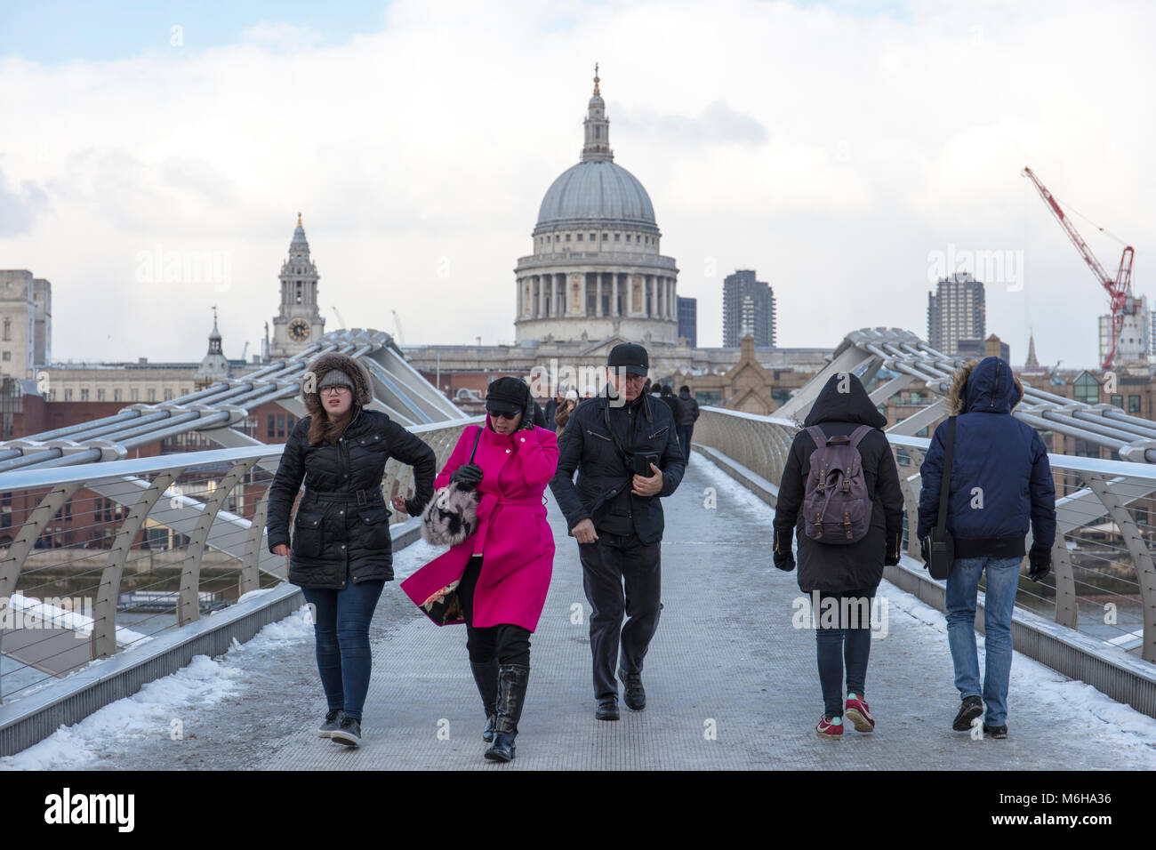 Menschen tragen warme Kleidung gehen über den Millennium (verwackelte) Brücke in der Nähe von St Paul's Cathedral in einem kalten Winter. Stockfoto
