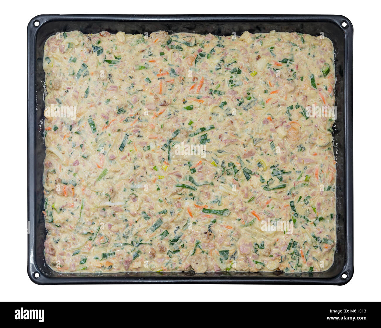 Schwarz Backblech mit rohen Teig. Der salzige festliches Brot mit geräuchertem Fleisch, Gemüse und Kräuter. Auf weissem Hintergrund. Stockfoto