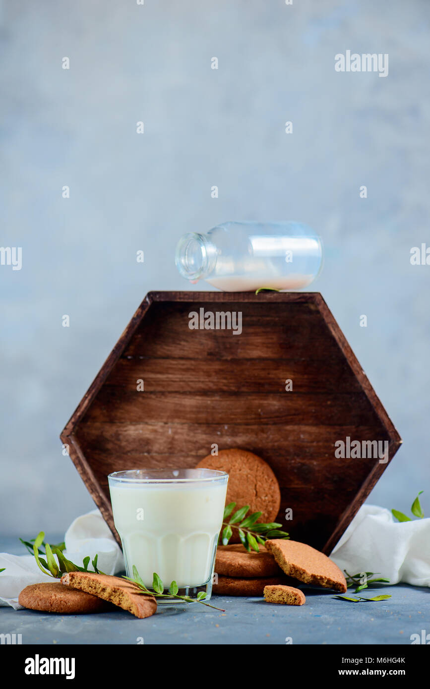 Milch und Cookies mit einer Flasche und Holz- fach High key Essen Fotografie auf einen konkreten Hintergrund mit kopieren. Stockfoto