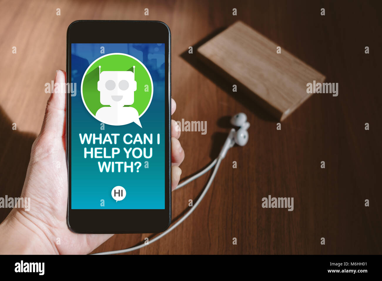 Benutzer Hand mobile Chat mit bot auf Telefonbildschirm an blur Holz Tisch Chat, gemeinsame Nutzung von Videos auf Social Media Konzept, Digital Marketing Strategie Stockfoto