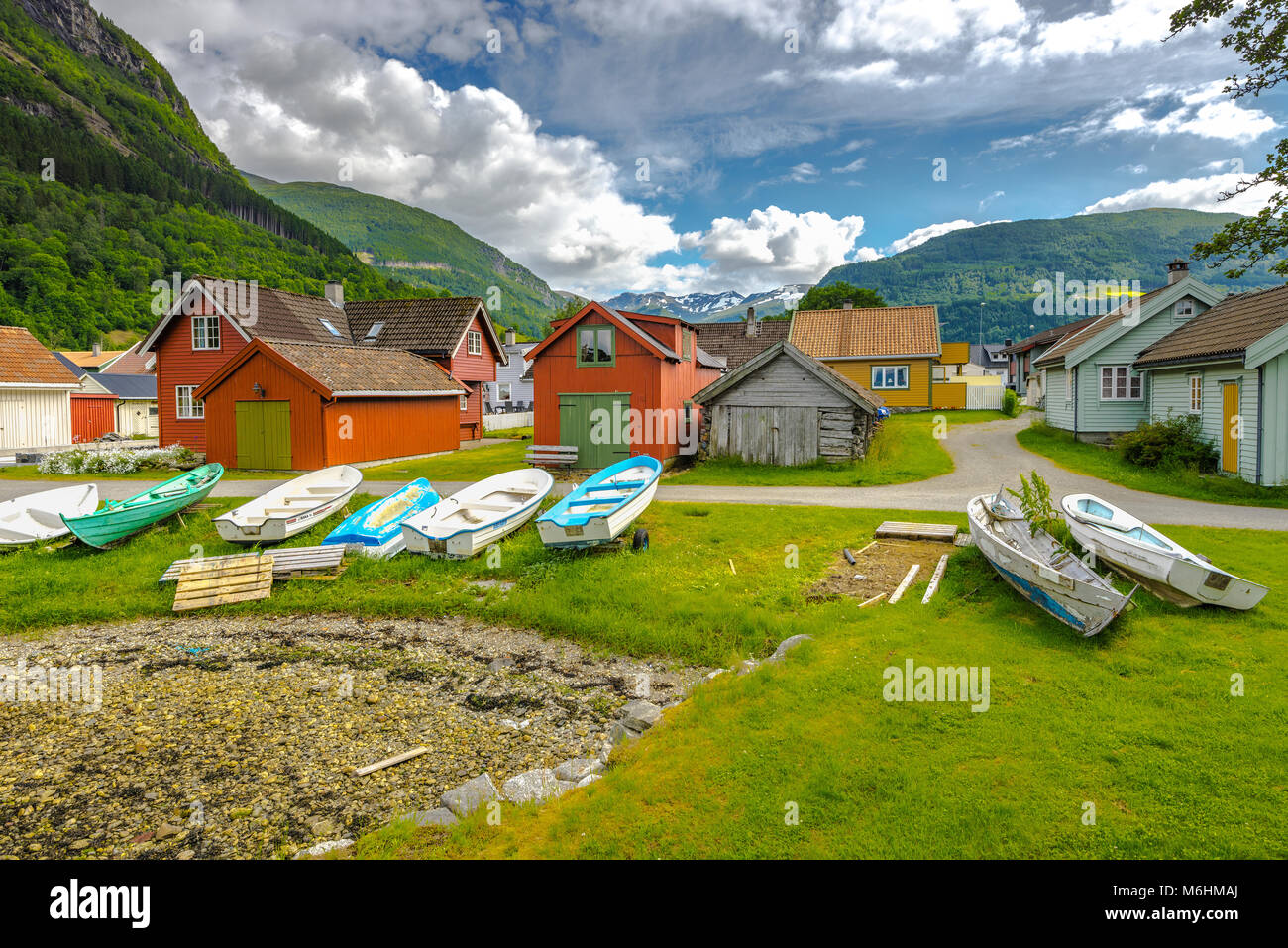 Bunte Hütten und Boote an der Küste im Vik, Norwegen, schneebedeckten Berge im Hintergrund, Sogn und Fjordane Stockfoto