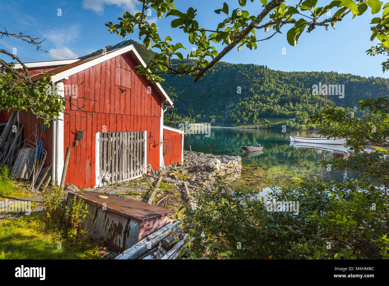 Rote Schuppen an der Küste von Balestrand, Norwegen, typische Holzhütte mit Blick auf den Sognefjorden Stockfoto