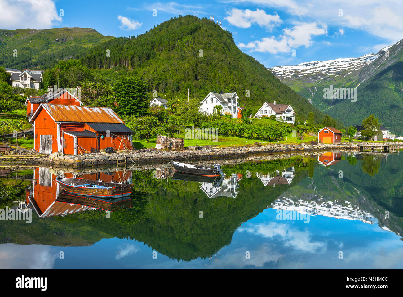 Boote und roten Fischer Hütte, Norwegen, Küste und die Bucht von Balestrand mit Spiegelung der Schnee in den Bergen, Esefjorden, Sognefjorden Stockfoto