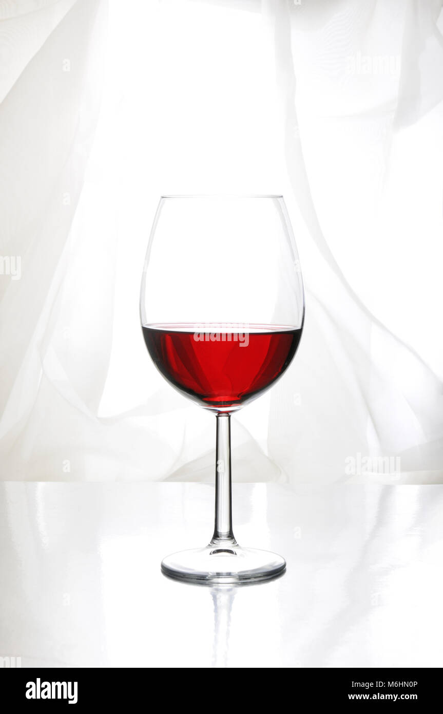 Ein Glas Rotwein in Bordeaux-Glas auf einem hellen Hintergrund Stockfoto