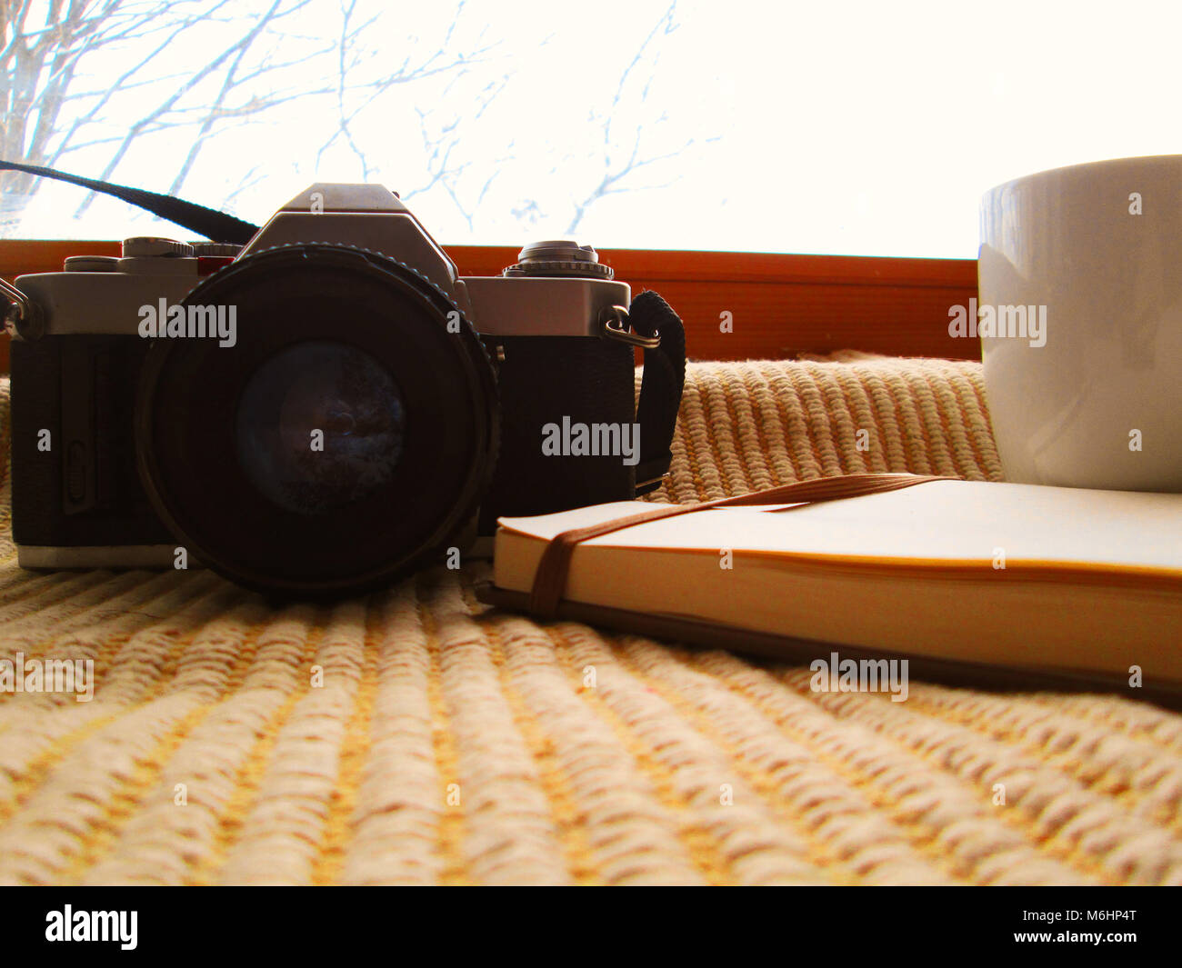 Winter Fotografie, weiße Tasse mit Kaffee analoge Kamera, Buch, Wollsocken, Vintage Style, Arbeitsplatz Stockfoto