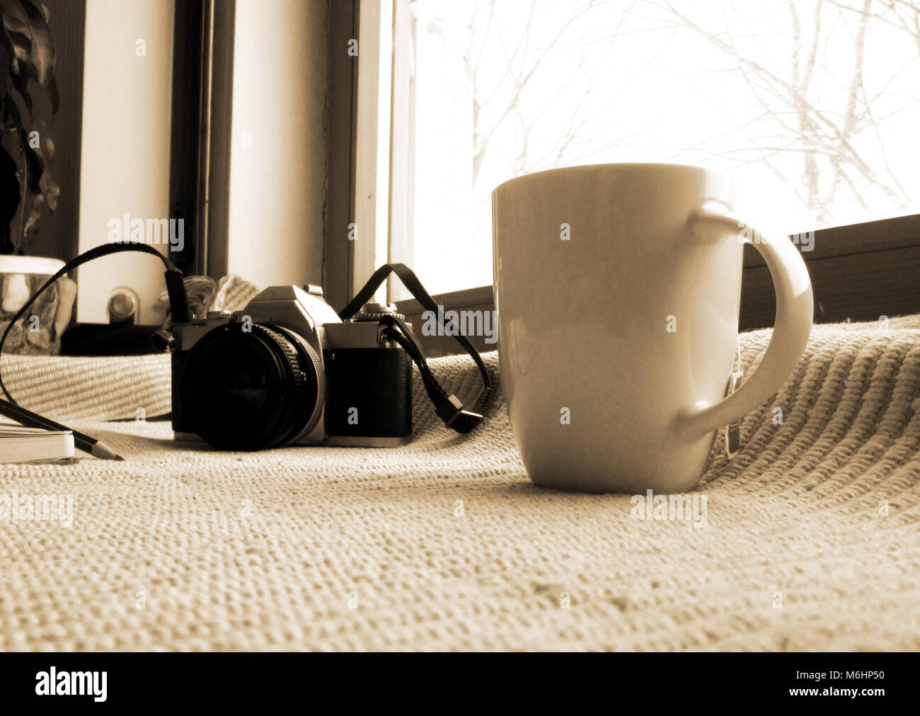 Winter Fotografie, weiße Tasse mit Kaffee analoge Kamera, Buch, Wollsocken, Vintage Style, Arbeitsplatz Stockfoto