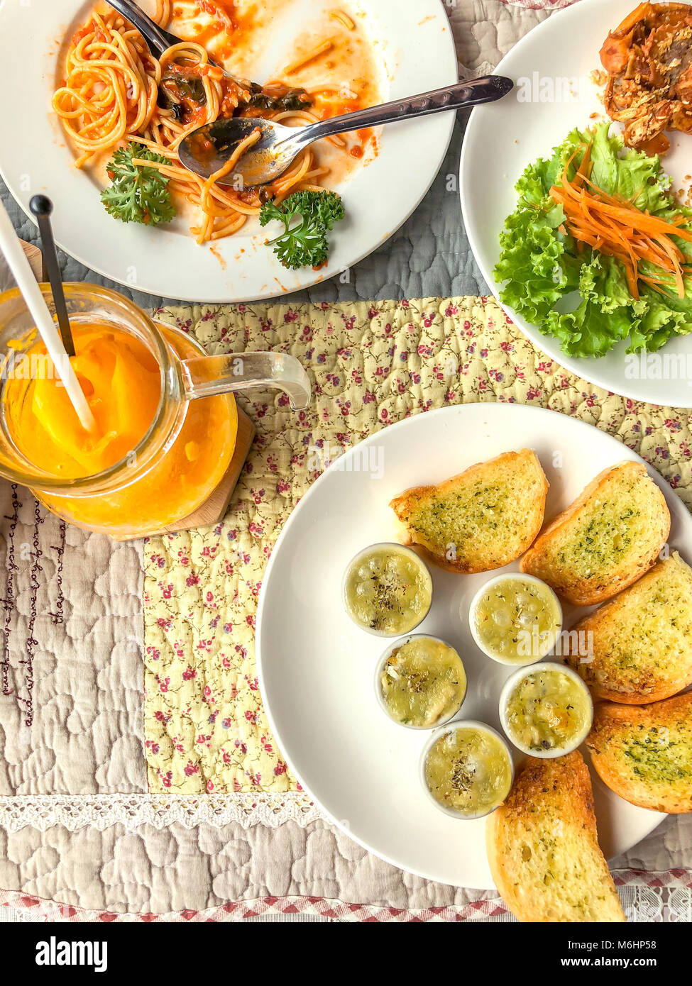 Gebackene frittierte Venusmuscheln mit Käse und Brot, Spaghetti Tomatensoße, gebratenen Soft Shell Crab und orange Smoothie in Jar Stockfoto