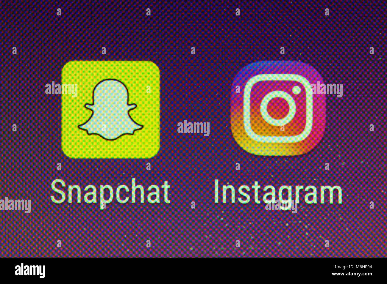 Eine Nahaufnahme des Snapchat und Instagram app Symbole auf einem Bildschirm des Smartphones Stockfoto