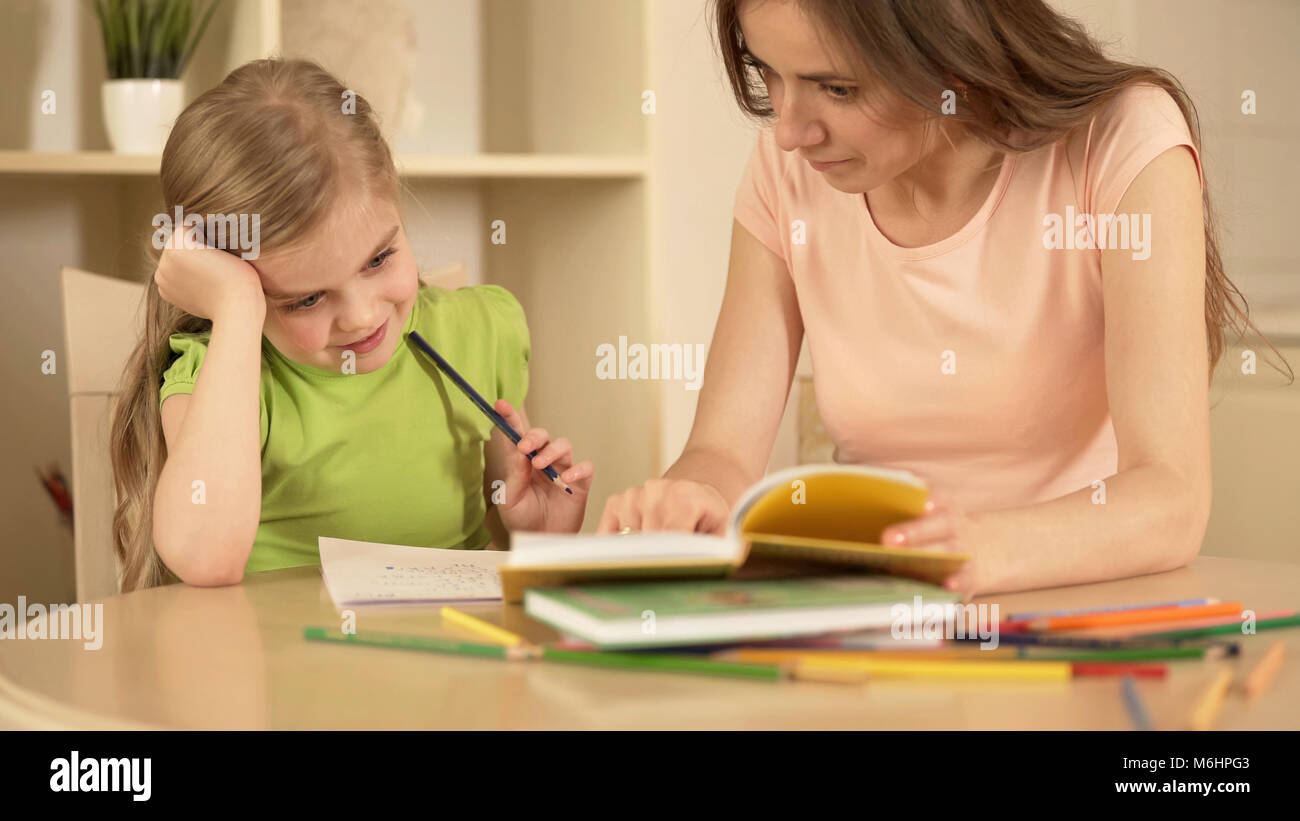 Mutter, Tochter mit Hausaufgaben, glücklich, intelligentes Mädchen genießen Home Education Stockfoto