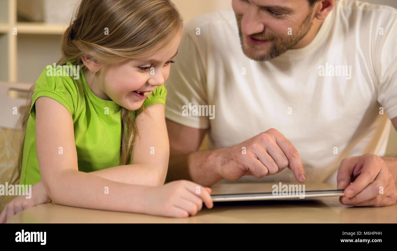 Gerne Vater und Tochter genießen Lustig pädagogische Anwendung auf Tablet PC Stockfoto
