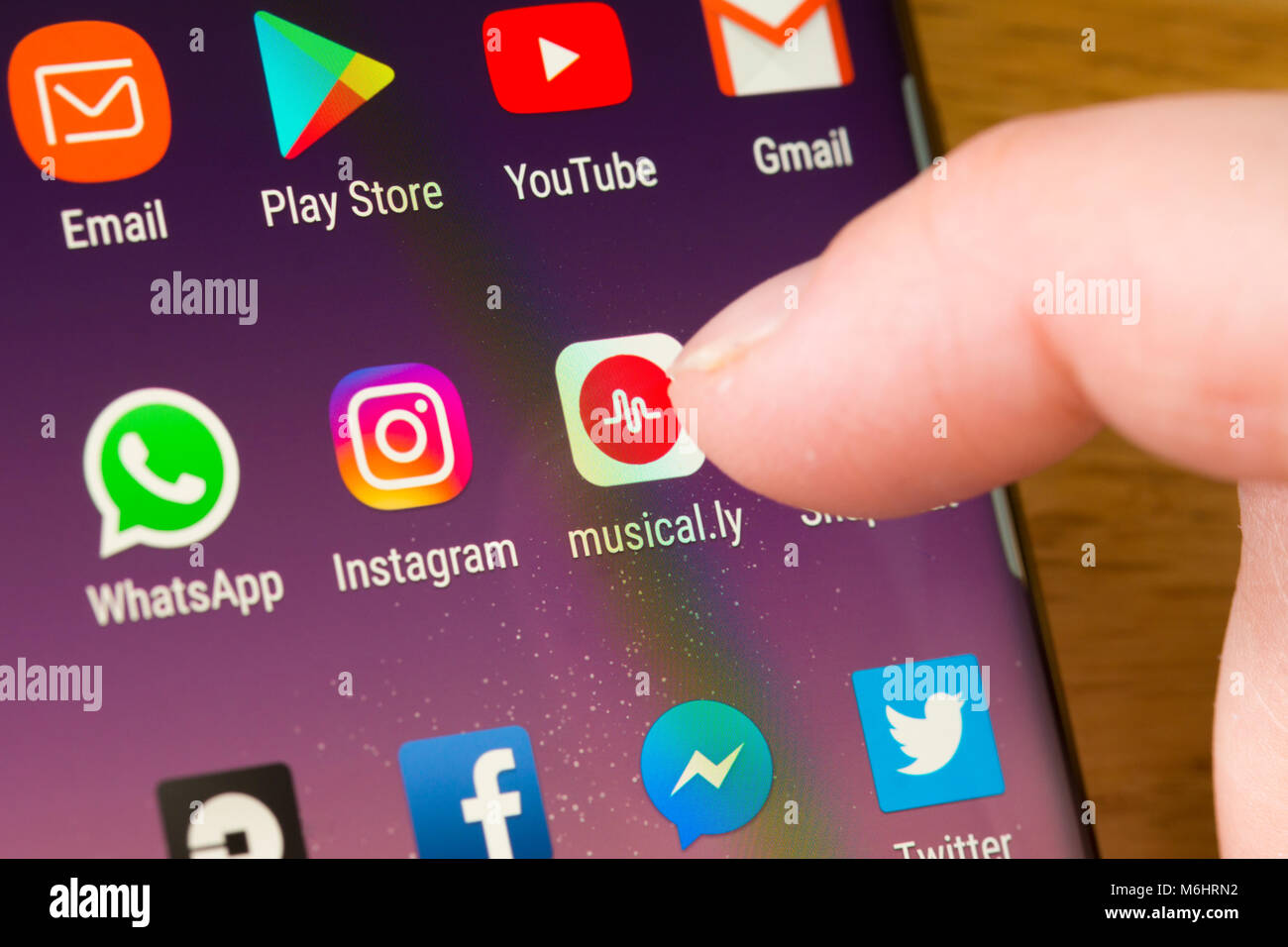 Nahaufnahme der App musical.ly auf einem ausgewählten Smartphone Durch den Finger einer Frau, die auf die App auf dem zeigt Handybildschirm Stockfoto