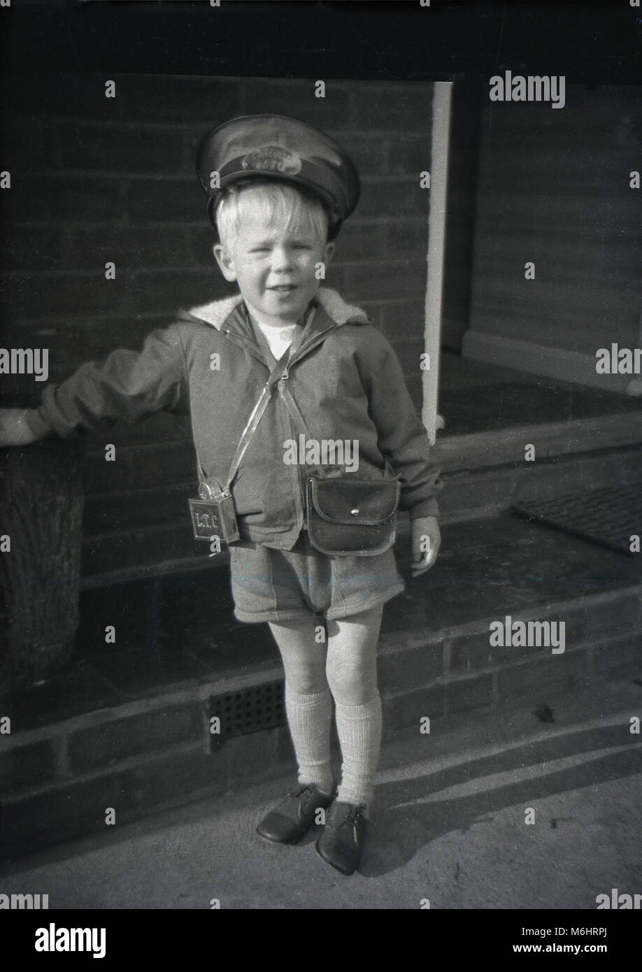 1960, historische, blonden jungen englischen Jungen außerhalb tragen oder ein Bus Dirigent Outfit der Gap, Geld Tasche und Metall ticket Punch stehend, ein beliebtes Kind' Dressing - bis Kostüm dieser Epoche. Stockfoto