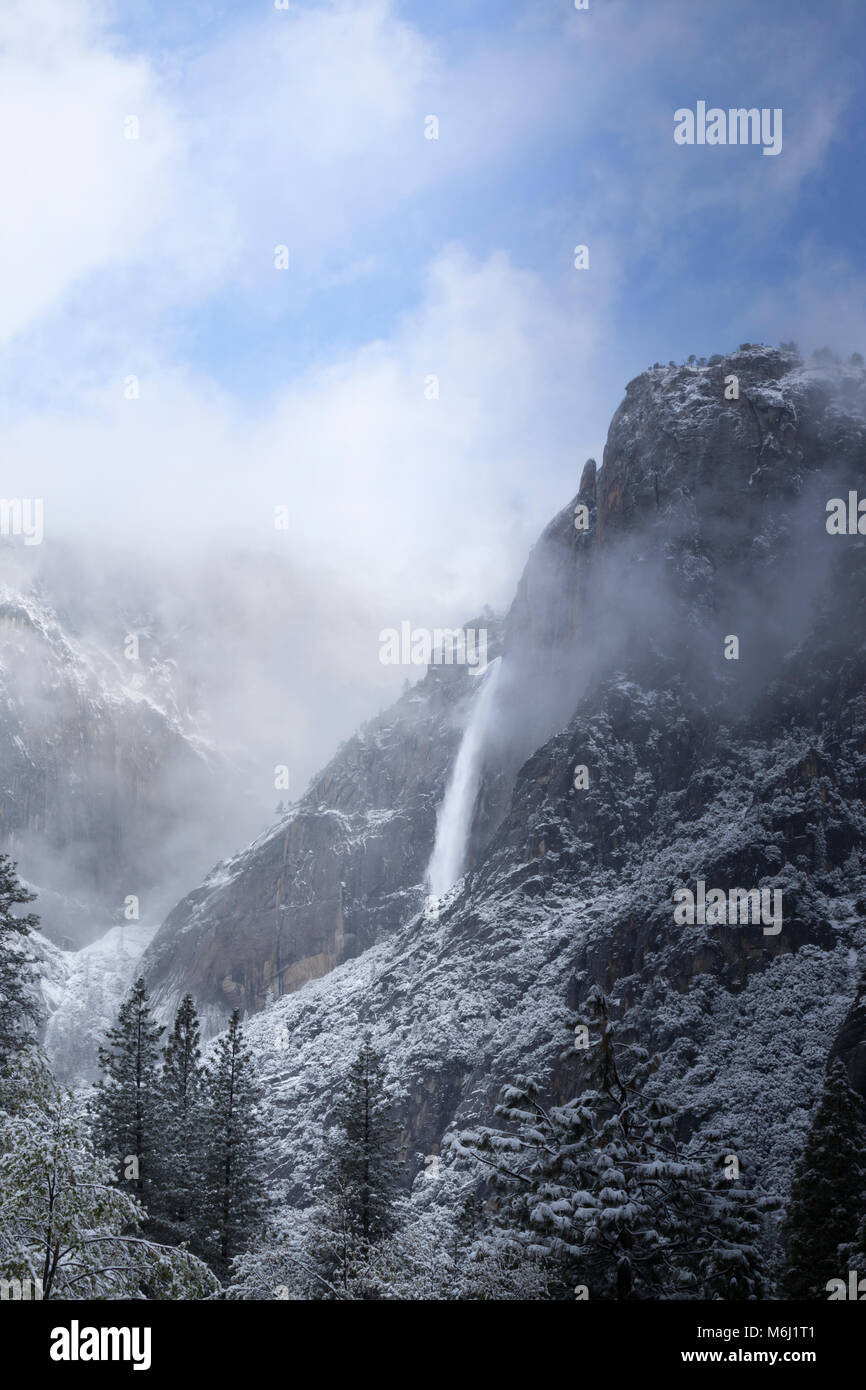 Landschaftlich schöne friedliche Yosemite Falls Wasserfall mit wispy niedrige Wolken über schneebedeckte Berge nach Frühling Schnee, Yosemite National Park, USA Stockfoto