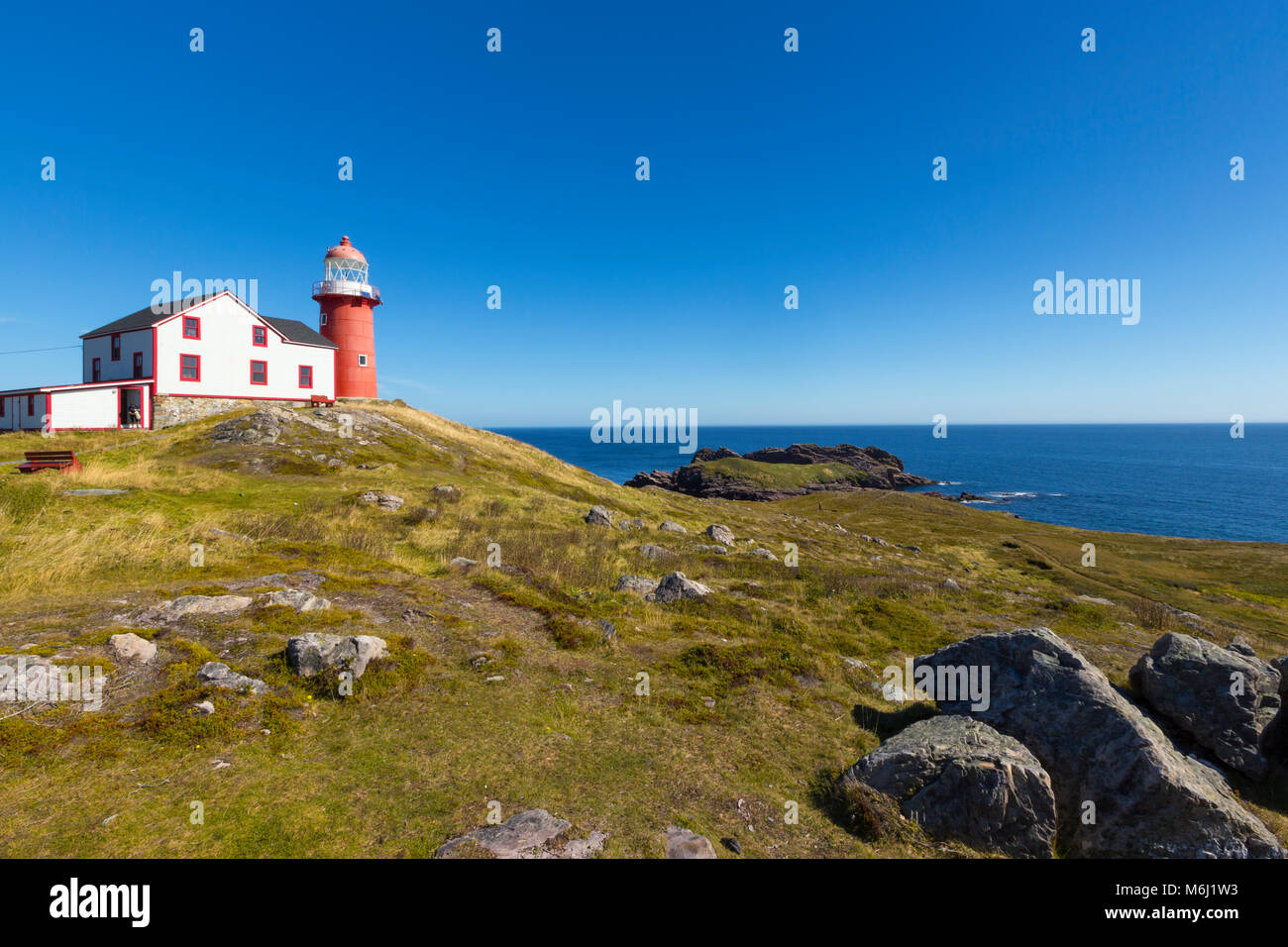 Neufundland Küste malerische Landschaft von Ferryland Leuchtturm und zerklüftete Küste mit schönen blauen Himmel, Meer und großen Felsen 1 Person auf fernen Pfad Stockfoto