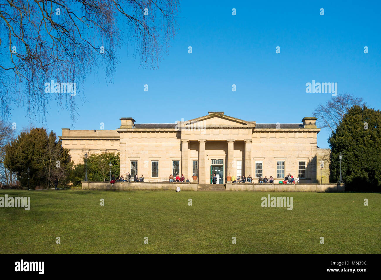 Leute genießen Winter Sonnenschein außerhalb des Yorkshire Museum Museum Park im Stadtzentrum von York England Stockfoto