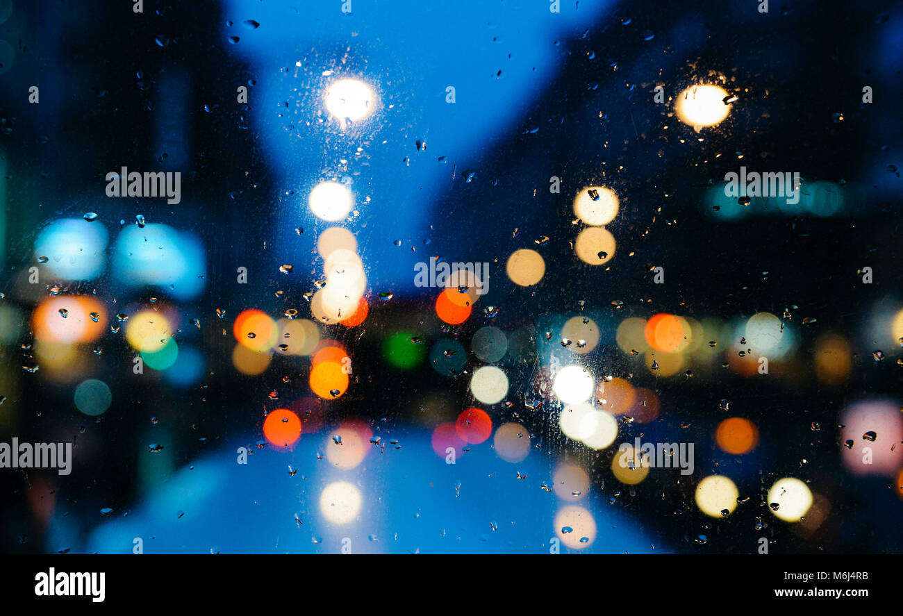 Emotionale romantisch Abstrakt Hintergrund mit Defokussierten Lichter in London bokeh, UK hinter Regen fällt in Fensterglas, konzentrieren sich auf wenige Tropfen aufgrund der geringen Tiefenschärfe Stockfoto