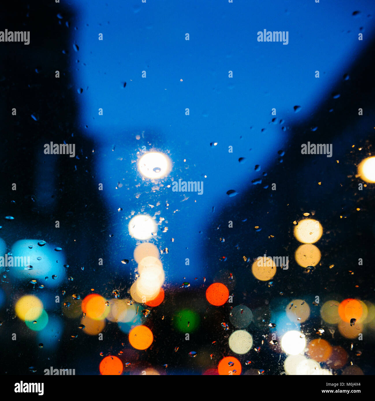 Emotionale romantisch Abstrakt Hintergrund mit Defokussierten Lichter in London bokeh, UK hinter Regen fällt in Fensterglas, konzentrieren sich auf wenige Tropfen aufgrund der geringen Tiefenschärfe Stockfoto