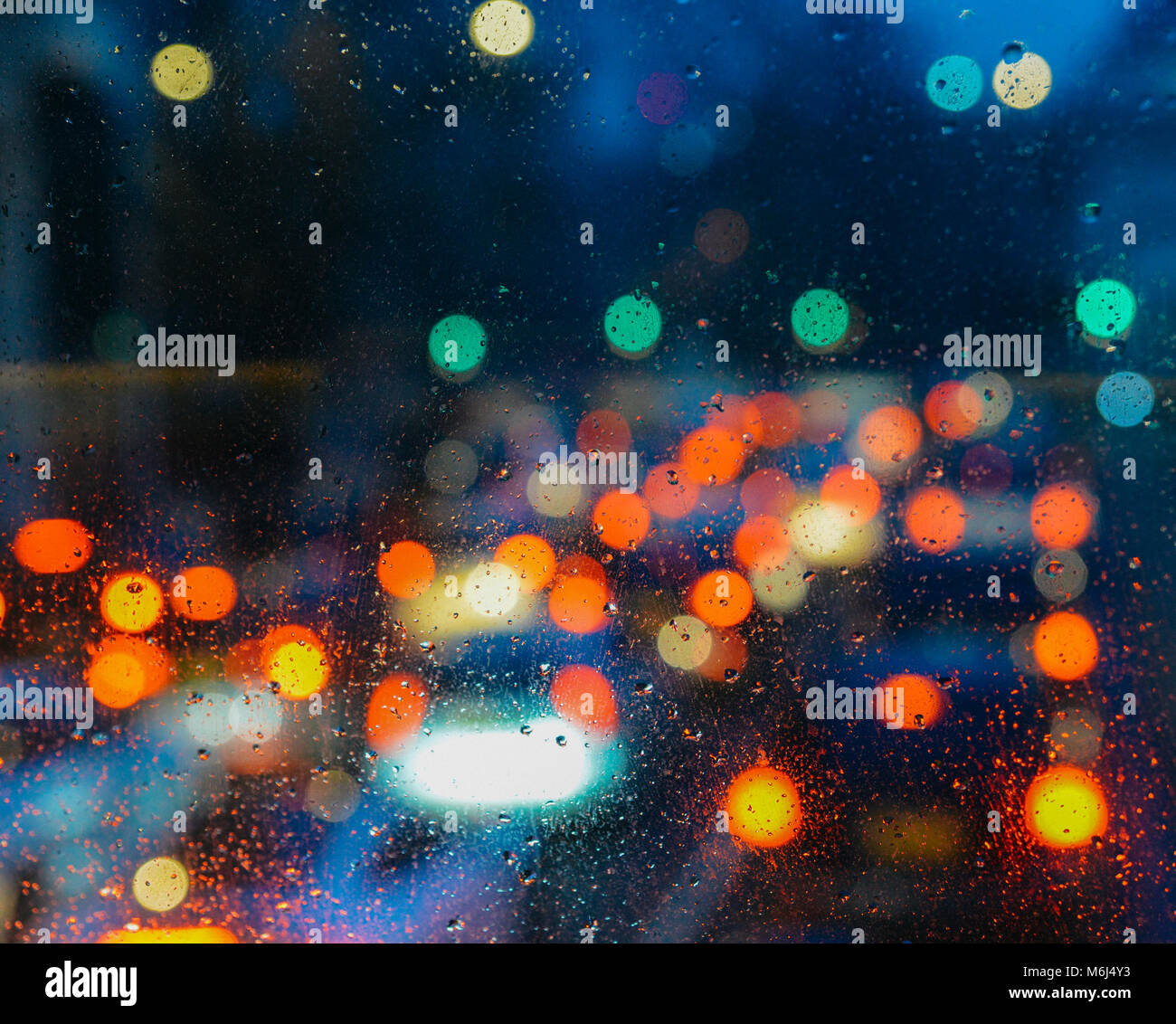 Emotionale romantisch Abstrakt Hintergrund mit Defokussierten Lichter in London bokeh, UK hinter Regen fällt in Fensterglas, konzentrieren sich auf wenige Tropfen aufgrund der geringen Tiefenschärfe Stockfoto