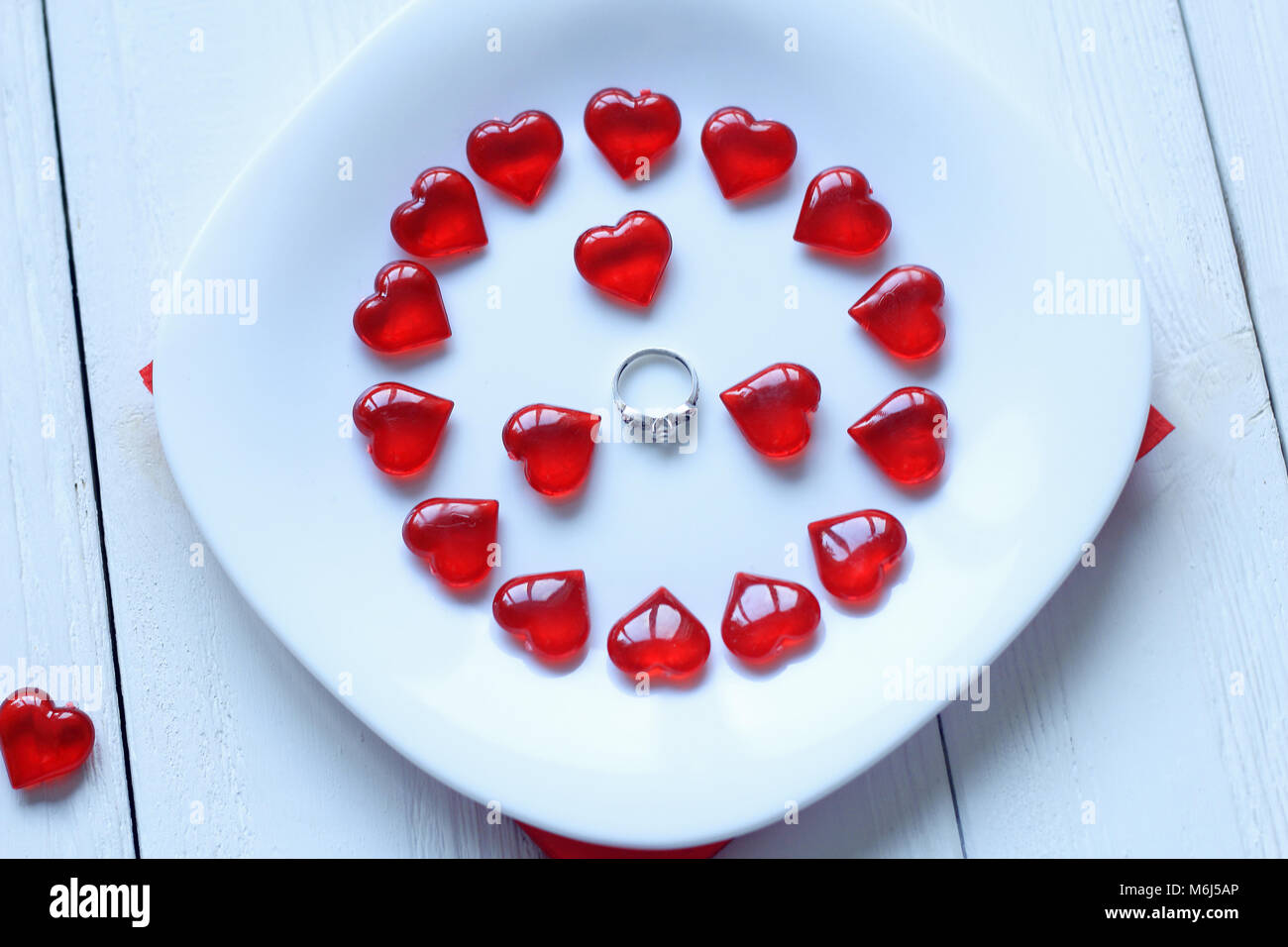 Bis zu schließen. Ring und roten Herzen auf einem weißen Teller Stockfoto