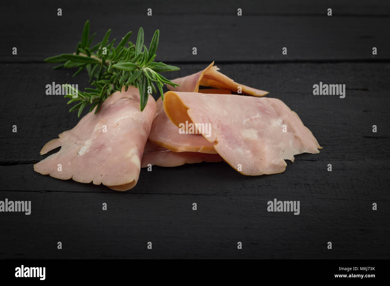 Wurst Schinken Scheiben auf rustikalen schwarzer Holztisch mit Platz für Text im Hintergrund oder Vordergrund Stockfoto