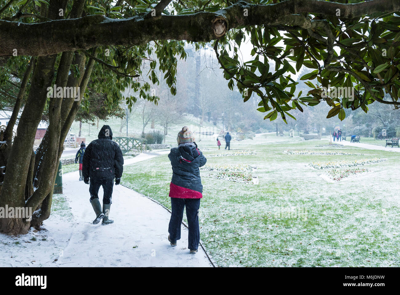 Menschen zu Fuß durch Schnee in Trenance Gärten in Newquay Cornwall. Stockfoto