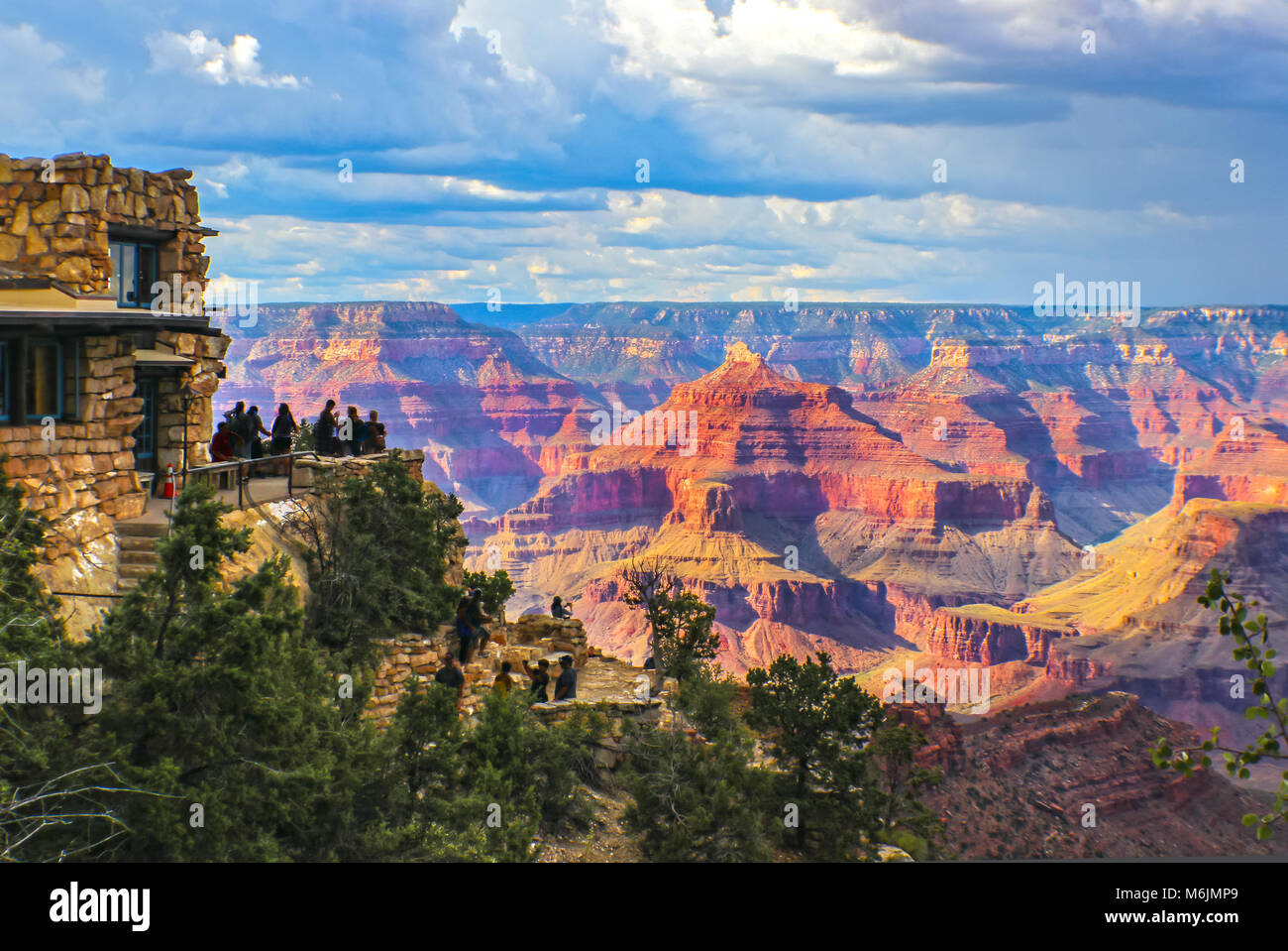 Grand Canyon South Rim Blick auf goldene Stunde unter stürmischen Himmel mit Touristen am Aussichtspunkt Aufnehmen von Bildern und selfies Stockfoto