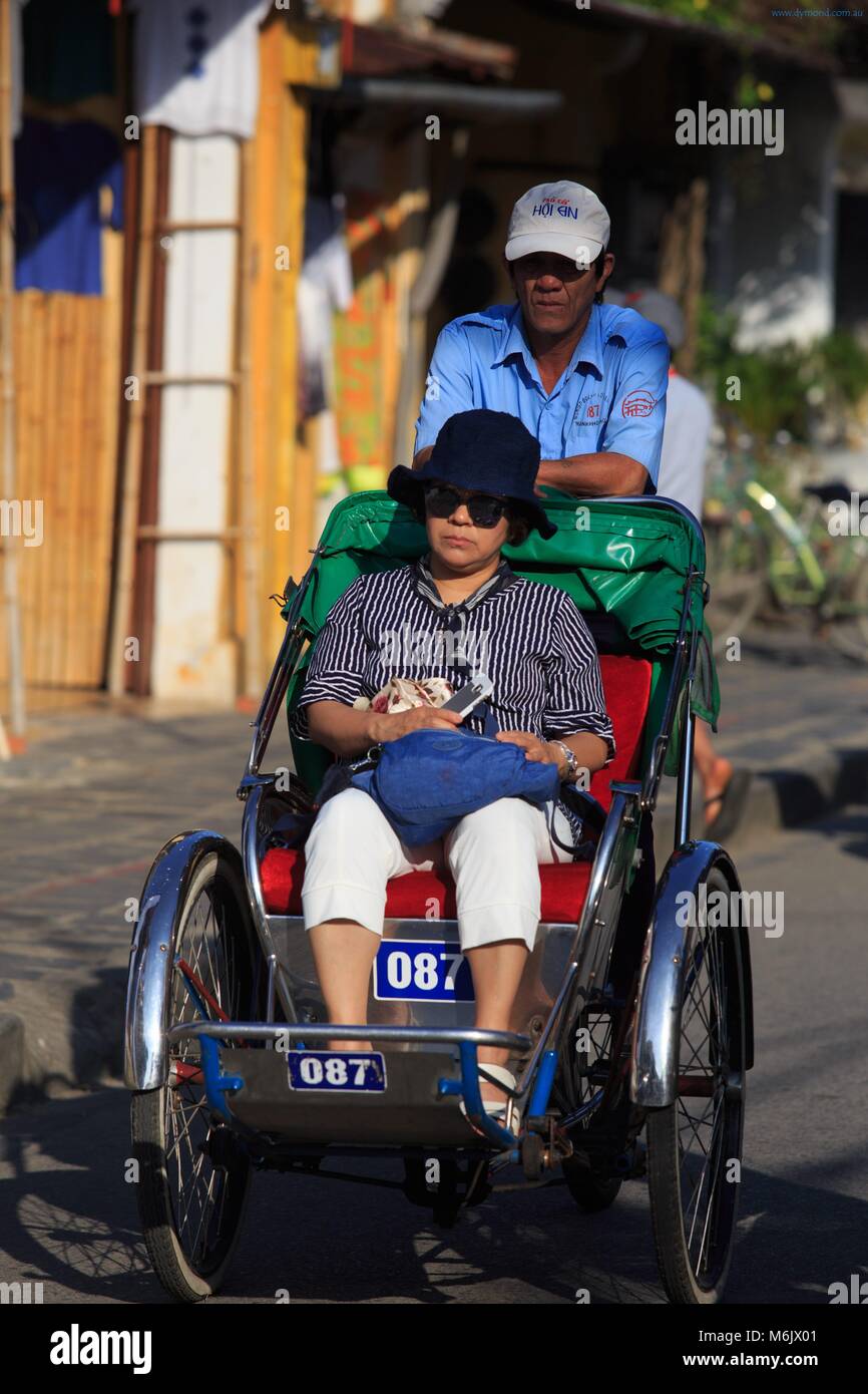 Dreirad Rikschas sind ein beliebter Weg für Touristen durch die Straßen der Altstadt von Hoi An, Vietnam zu reisen. Stockfoto