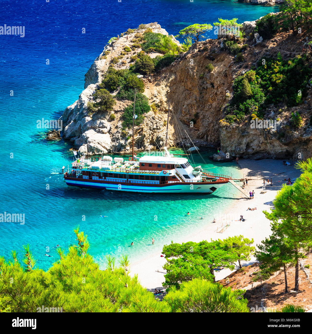 Schöne Apella Strand, Ansicht mit azurblauen Meer und Schiff, Karpathos, Griechenland. Stockfoto