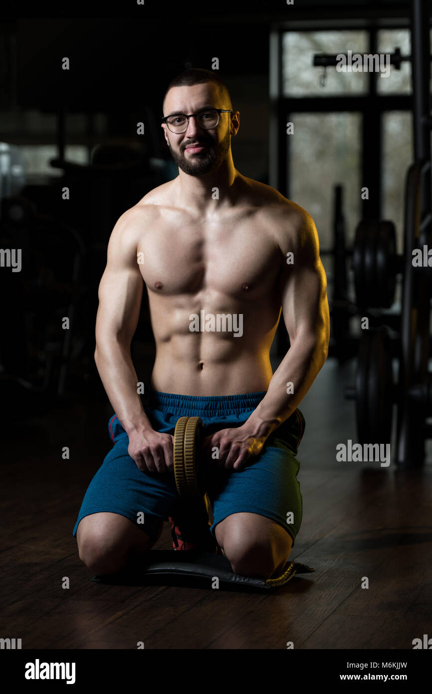 Junger Mann Brille trainieren Fitness Workout für die Abdominaldiagnostik mit Toning Rad Stockfoto