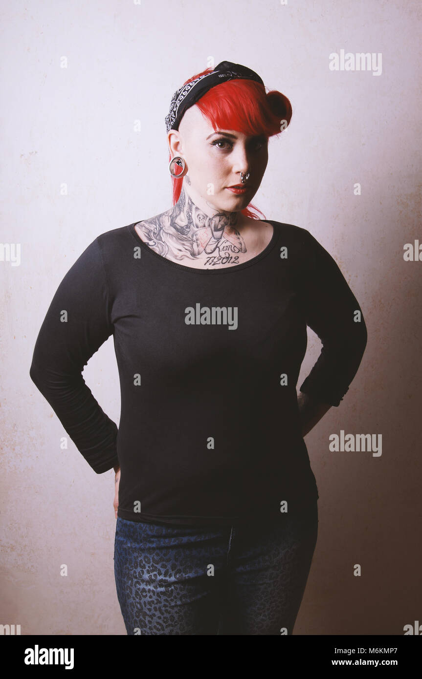 Nervöse Porträt einer jungen Frau mit vielen Gesichts Piercings und Tattoos Stockfoto