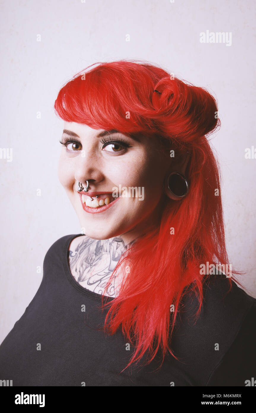 Durchbohrt und tätowierte junge Frau mit toothy Lächeln Stockfoto