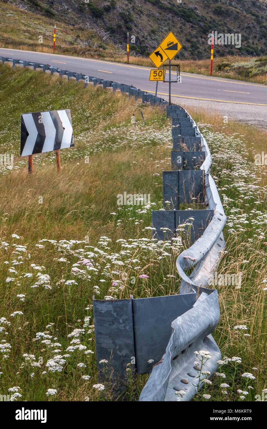 Wicklung zweispurigen Autobahn durch die australischen Alpen Region mit gelben Streifen, Kurve Zeichen roter Schnee Polen und sanften Hügeln und abgerundete Berge Stockfoto