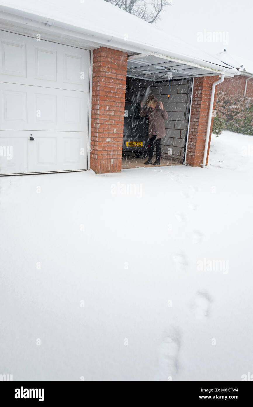 Frau in der Garage winter UK Stockfoto