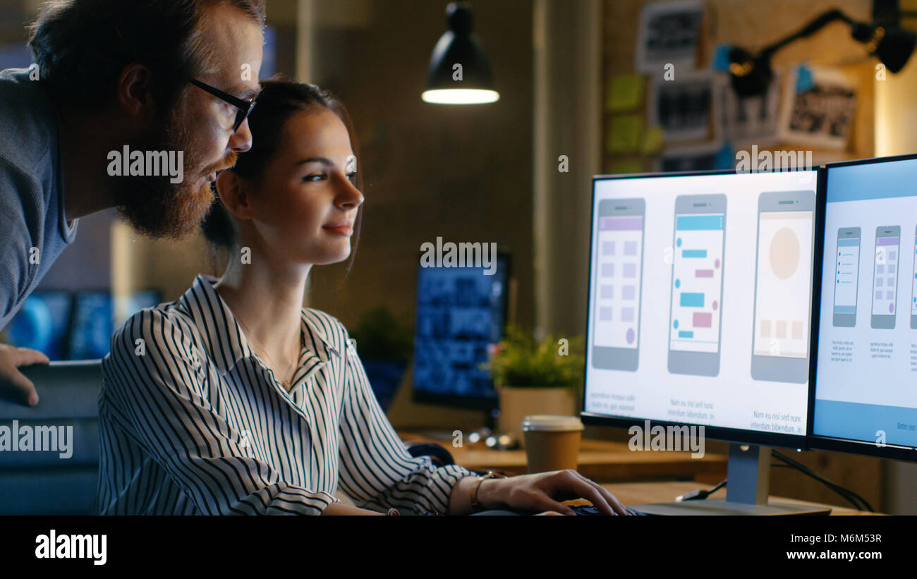 Weibliche UX Architekt hat Diskussion mit männlichen Design Engineer, Sie arbeiten auf Mobile Anwendung spät in der Nacht, Sie trinkt Kaffee. Loft, moderne Büro. Stockfoto