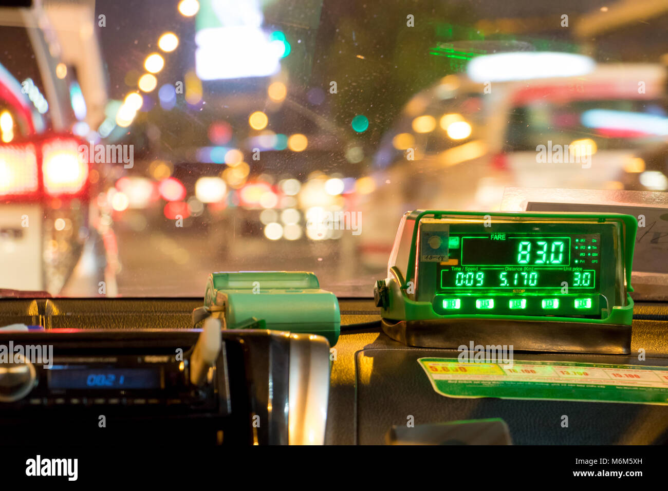 Die digitale Taxameter auf dem Armaturenbrett des Cab zeigt Kilometer und Kosten. Nacht mit dem Taxi im Stau. Stockfoto