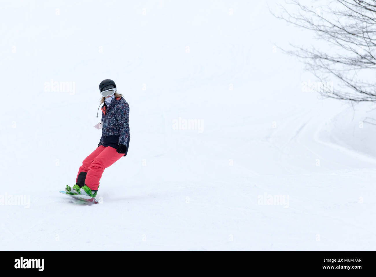 Weibliche Snowboarder auf der Piste Stockfoto